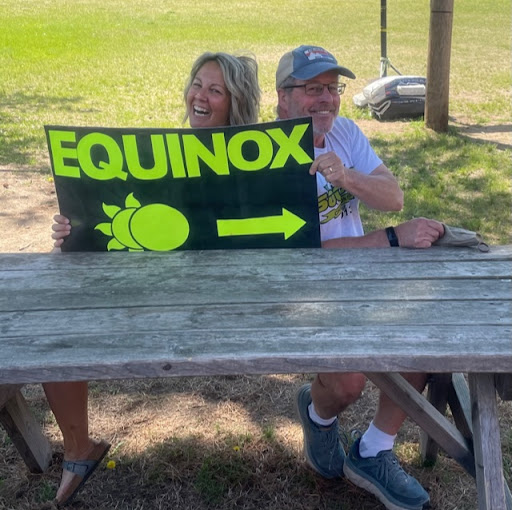 Photo of Ms. Chayer and Mr. Pease at a picnic table holding a sign that says Equinox.