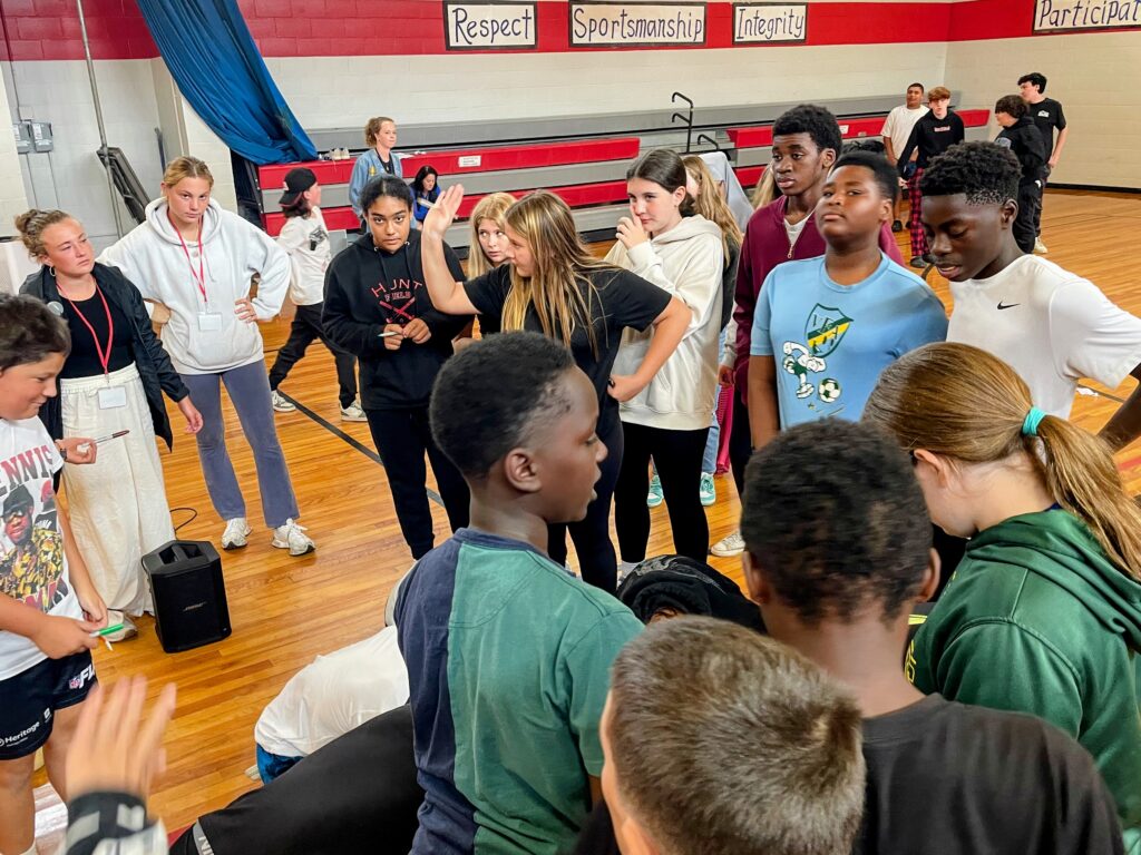 A group of students mingling in the gym.