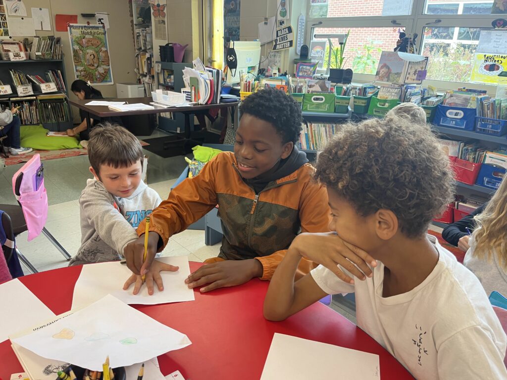 middle school student tracing hands of elementary student